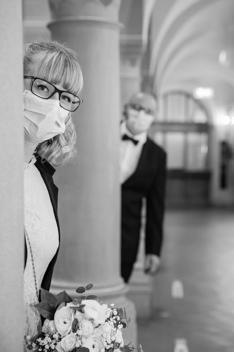 Ziviltrauung Corona -UTZ_6596 Paar lächelt sich mit Masken an – Freude trotz Pandemie, fotografiert in Zürich.
